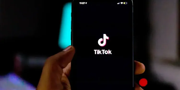 Pessoa segura celular com a tela inicial do TikTok aberta