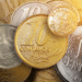 Moeda brasileira de 10 centavos de 1998 destacada em primeiro plano, cercada por outras moedas antigas