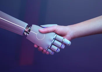 Mão humana apertando a mão de um robô em um fundo futurista.