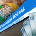 Fachada do prédio do INSS com cédulas de dinheiro, simbolizando benefícios financeiros.