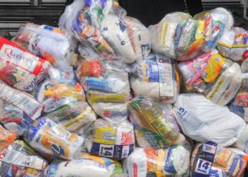 Cestas básicas empilhadas com diversos alimentos.
