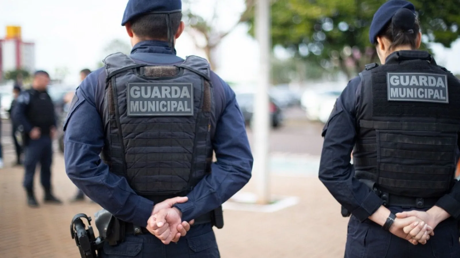 guardas municipais uniformizados em patrulhamento urbano.
