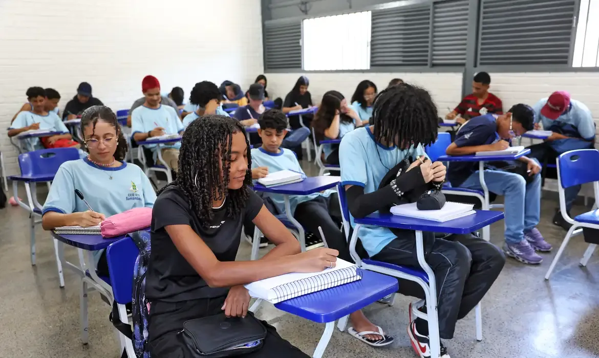 Pagamento Pé-de-Meia Estudantes em sala de aula durante atividade escolar.