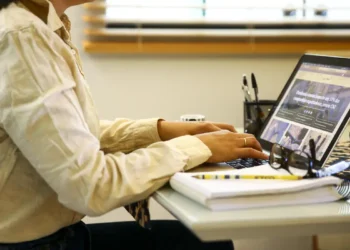 Pessoa digitando no notebook enquanto acompanha prazos importantes em ambiente de trabalho.