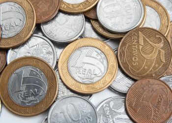 Moedas brasileiras de diferentes valores espalhadas