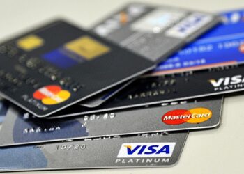 Cartões de crédito espalhados sobre uma mesa, representando o endividamento no cartão e a necessidade de gerenciar finanças pessoais.