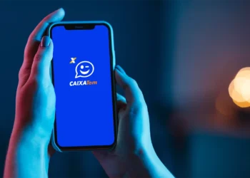 Pessoa segurando celular com o aplicativo Caixa Tem aberto na tela.
