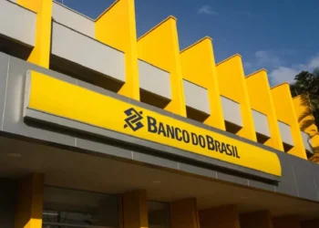 Fachada do Banco do Brasil, com a logo amarela e azul, em uma imagem representando o tema do concurso e a exigência de um novo edital pelo sindicato.