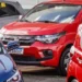 Fiat Mobi vermelho estacionado entre outros carros iluminados pelo sol.