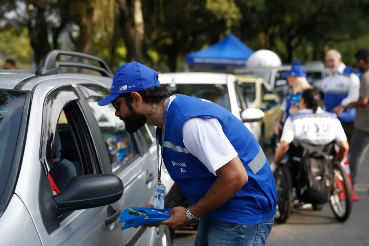Agente de trânsito aborda motorista em ação de fiscalização educativa nas ruas.