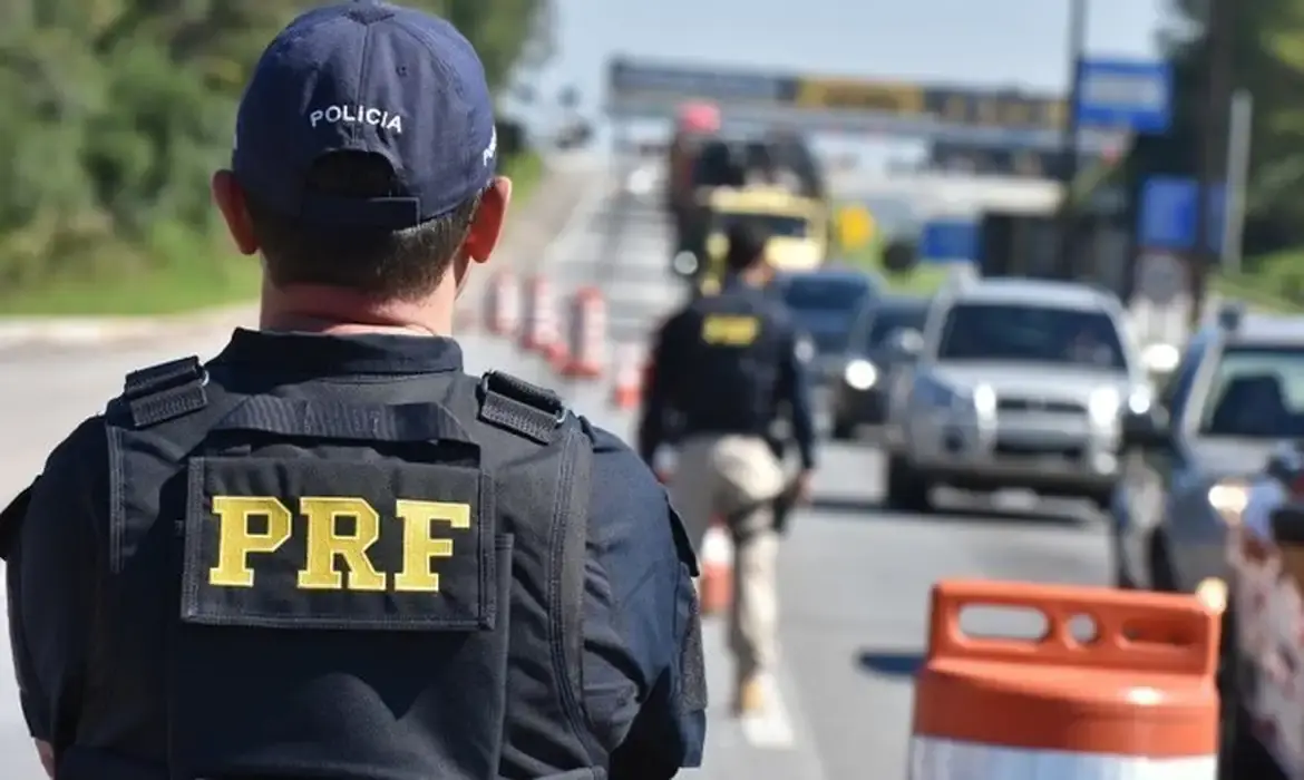 concurso PRF 2025 Agente da PRF monitora trânsito em rodovia durante operação