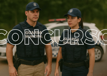 Dois agentes da Guarda Municipal uniformizados em frente a viatura.