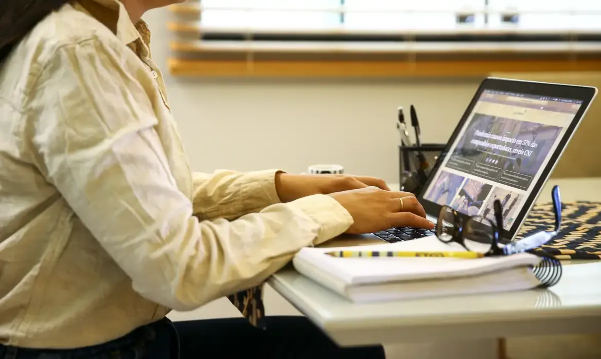 Curso gratuito Pessoa trabalhando em notebook em ambiente doméstico.