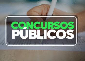 Mão preenchendo gabarito de concurso público com lápis sobre papel de prova