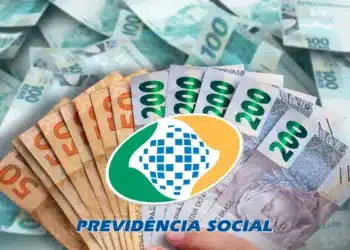 Notas de dinheiro em real com o logo da Previdência Social sobre fundo de notas de 100 e 200 reais, relacionado ao reembolso de descontos indevidos do INSS.