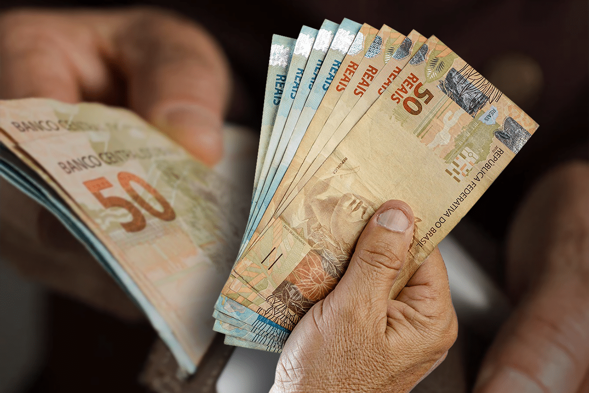 Pessoa segurando cédulas de real brasileiro representando contratos de empréstimo consignado