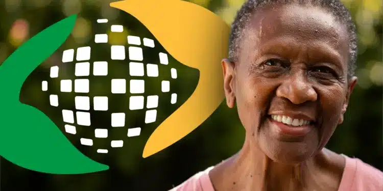 Senhora sorrindo com o símbolo do INSS ao fundo, representando o processo de prova de vida online.