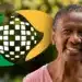 Senhora sorrindo com o símbolo do INSS ao fundo, representando o processo de prova de vida online.