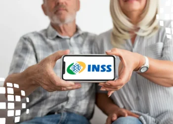 Pessoa idosa com celular exibindo o logo do INSS, referência para prova de vida digital em 2025.