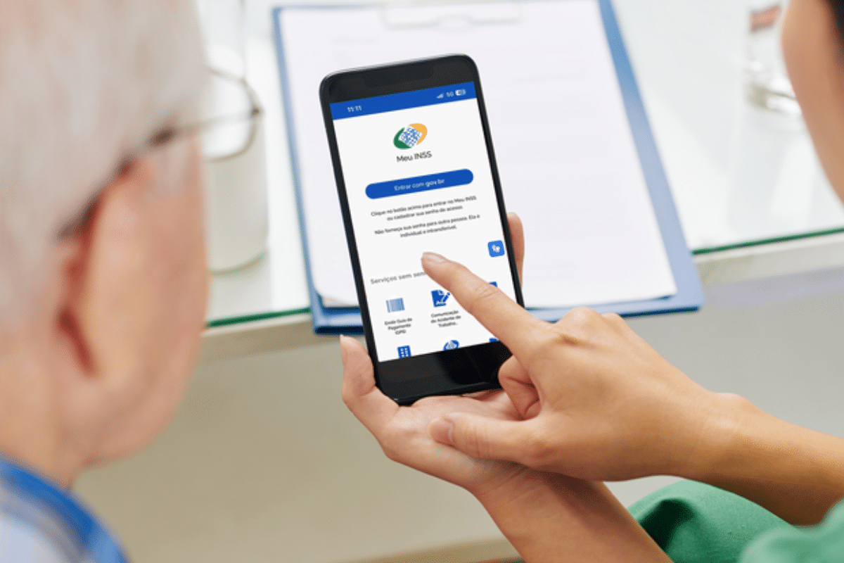 Pessoa utilizando o aplicativo Meu INSS em um smartphone para consultar serviços previdenciários