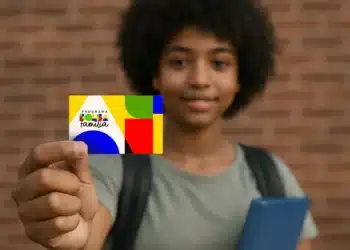 Jovem mostrando cartão do Programa Bolsa Família com design colorido.