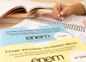 Estudante se preparando para o Exame Nacional do Ensino Médio (Enem), com materiais de estudo e provas simuladas em uma mesa.
