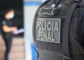 Agente da Polícia Penal em serviço com equipamento completo e colete tático
