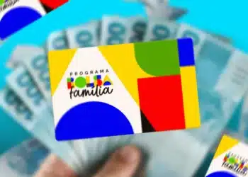 Cartão do Programa Bolsa Família com fundo colorido e cédulas de dinheiro ao fundo. A imagem reflete o benefício antecipado de outubro.