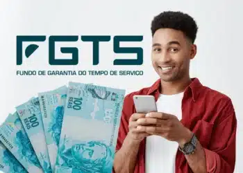 Homem sorridente segurando celular com cédulas de 100 reais e logo do FGTS ao fundo
