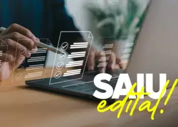 Candidato verificando edital publicado com informações sobre remuneração no notebook