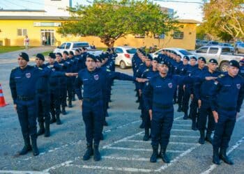 Grupo de guardas municipais em uniforme azul marinho alinhados em formação durante treinamento ao ar livre