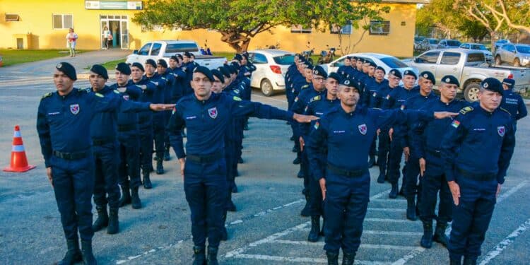 Grupo de guardas municipais em uniforme azul marinho alinhados em formação durante treinamento ao ar livre