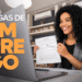 Mulher sorridente em entrevista de emprego online, segurando contrato em frente ao notebook.