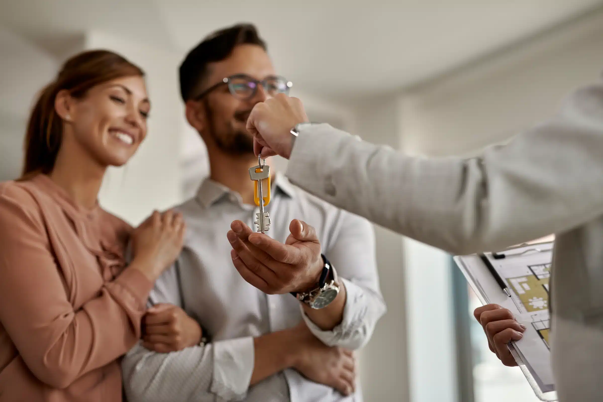 Casal recebendo as chaves de um imóvel, representando o impacto do aumento do teto de financiamento do SFH para R$ 2,25 milhões.