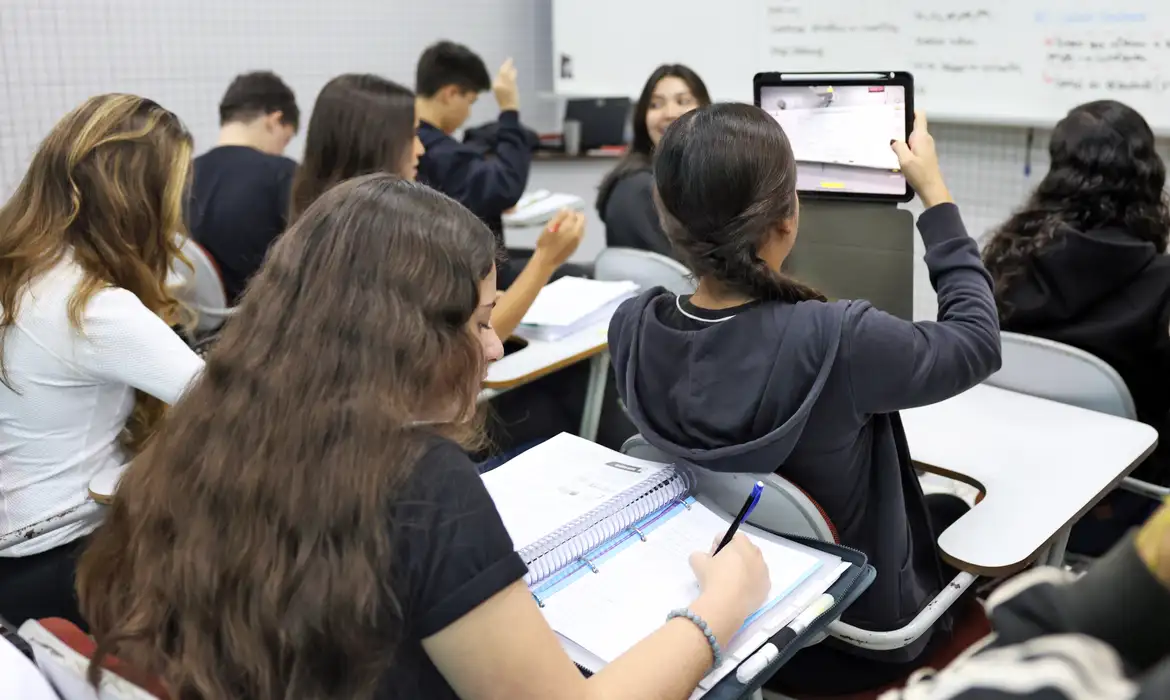 Prova do ENEM 2019 com Cartão-Resposta em mãos Mãos segurando prova do ENEM 2019 junto com cartão-resposta para exame nacional do ensino médio