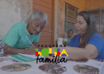 Idosa e assistente do CRAS realizando cadastro para o Bolsa Família em ambiente comunitário.