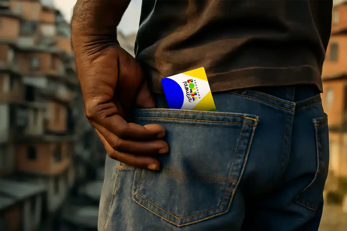 Cartão Programa Família no bolso de calça jeans Mão segurando cartão do Programa Família no bolso traseiro de calça jeans com fundo de comunidade urbana