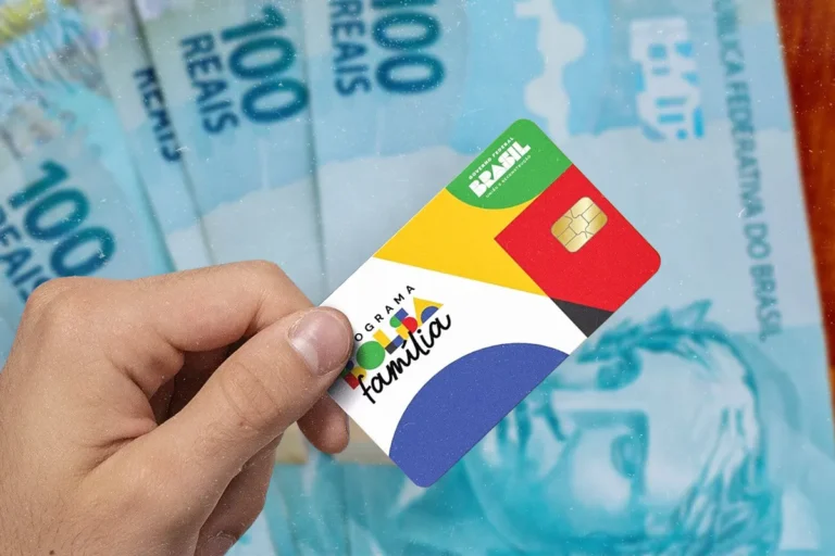 Cartão do Bolsa Família em primeiro plano, com notas de R$ 100 ao fundo, representando o benefício do programa social.