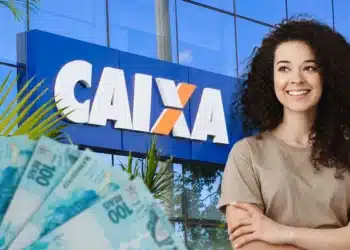 Mulher sorridente com cabelos cacheados posa com dinheiro em reais na frente da agência da Caixa Econômica Federal