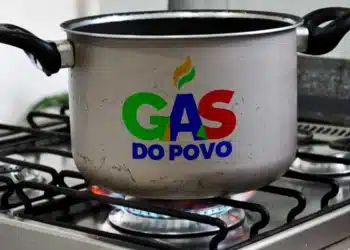 Panela no fogão com o logo “Gás do Povo”, representando o programa de auxílio ao gás.