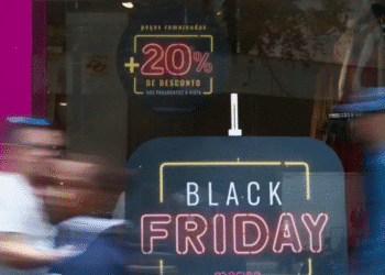 Letreiro em vitrine anunciando Black Friday com desconto adicional de 20% em peças remarcadas para pagamento à vista