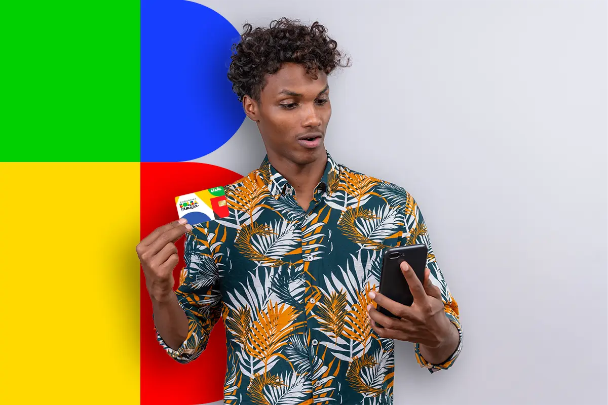 Valores do Bolsa Família em 2025 Beneficiário consultando valores do Bolsa Família 2025 no celular com cartão do programa em mãos.