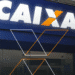 Fachada de uma agência da Caixa Econômica Federal com a logo em destaque.
