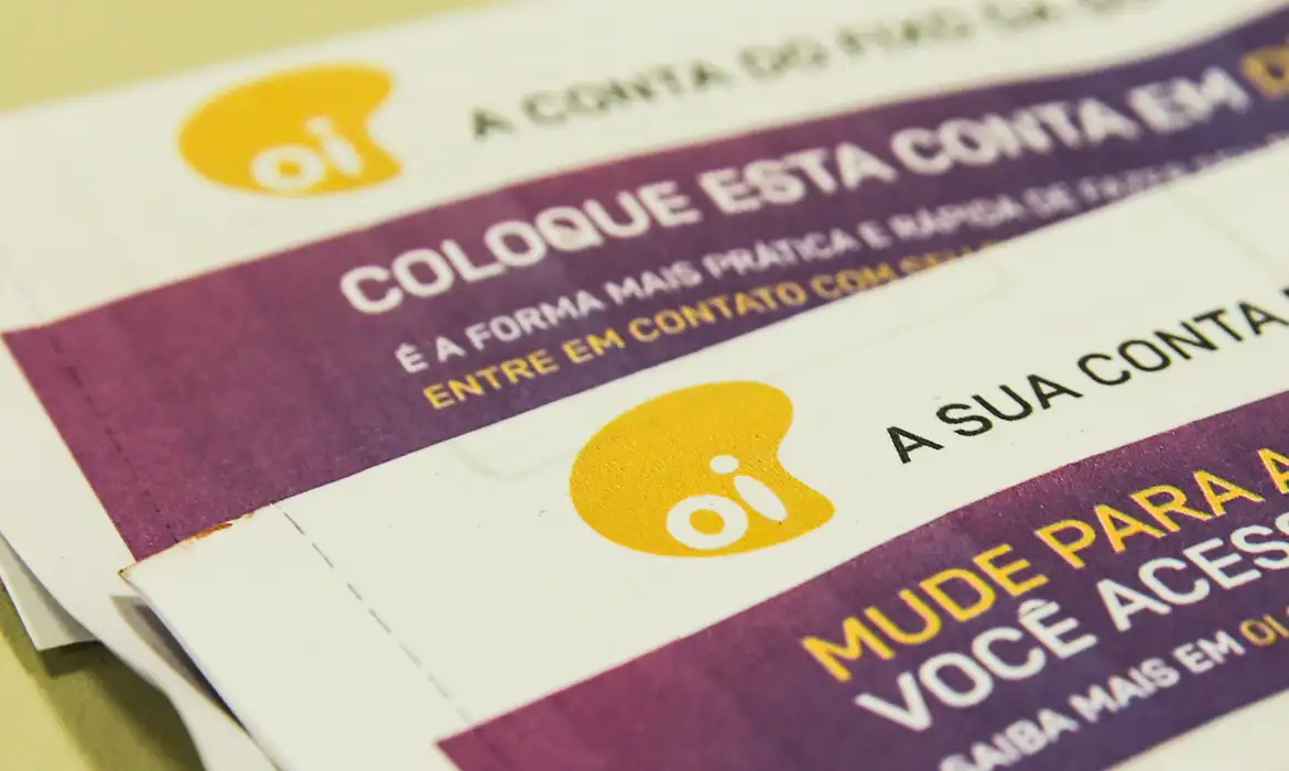 Detalhe de dois cartões da operadora Oi com instruções para mudar de conta e contato