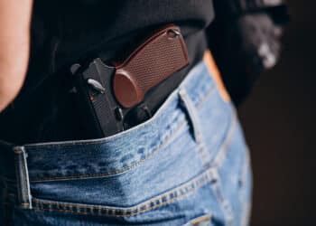 Armamento de agente de segurança pública guardado na cintura.