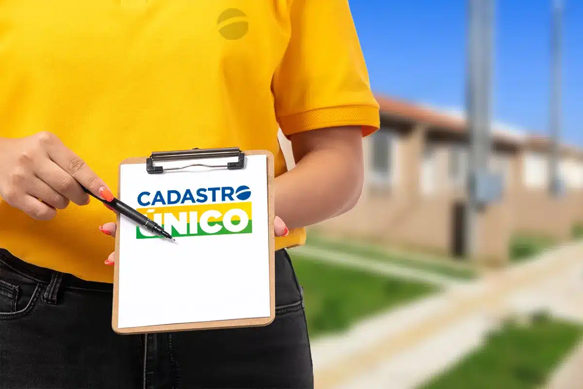 Cadastro Único: Como Atualizar Seus Dados para Garantir o Bolsa Família em 2026 Pessoa com camiseta amarela segurando uma prancheta com o logo do Cadastro Único, ressaltando a importância de atualizar os dados para garantir o Bolsa Família em 2026.