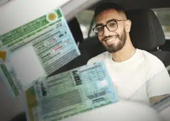 Motorista sorrindo ao lado de sua CNH, ilustrando o novo benefício de renovação automática de CNH para bons condutores proposto pelo governo Lula.