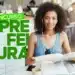 Candidata se preparando para concursos de prefeituras paulistas revisando conteúdo com material de estudo em ambiente externo.