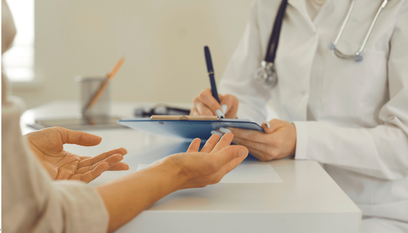 Atestado médico de papel Médico de jaleco branco fazendo anotações em clipboard durante consulta com paciente.