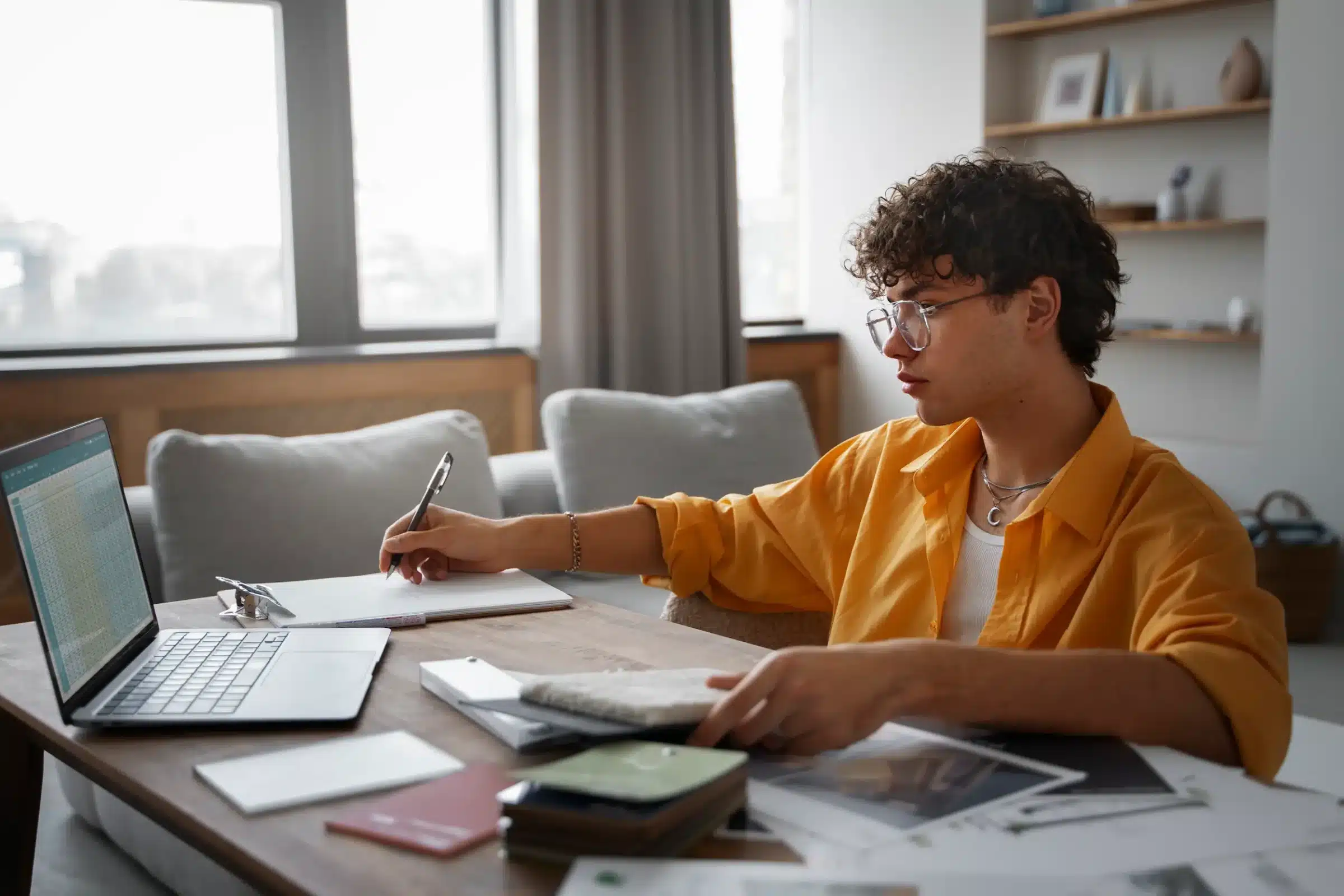 Pessoa estudando em um ambiente organizado e minimalista, com laptop e materiais de estudo em uma mesa, com foco na produtividade.